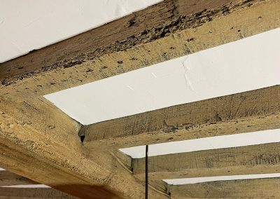 a close up shot of newly renovated wooden beams on white ceiling